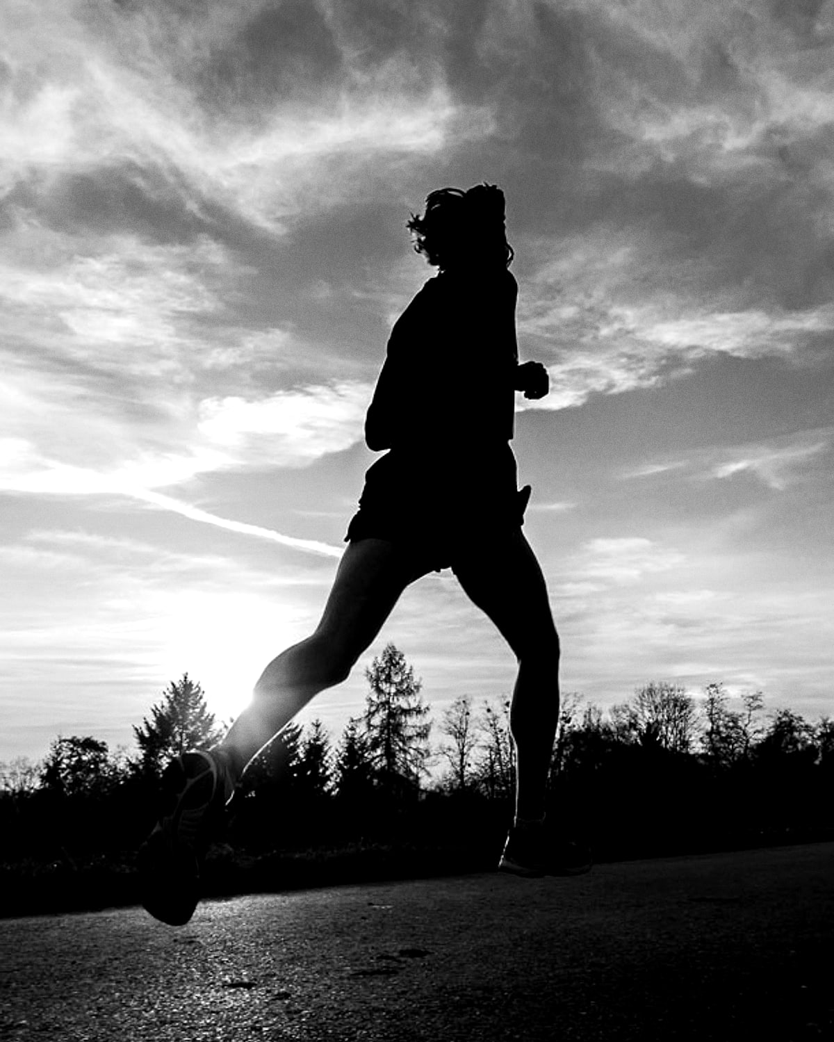 Corredor a contraluz entrenando al amanecer